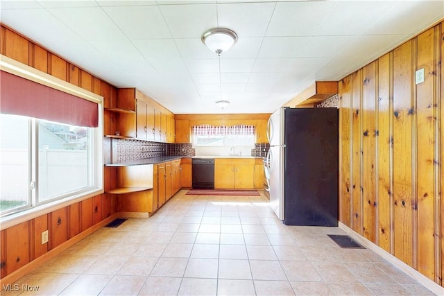 441 4th St, Bergholz, OH 43908 - kitchen with open shelves, dishwasher, wood walls, freestanding refrigerator, and visible vents