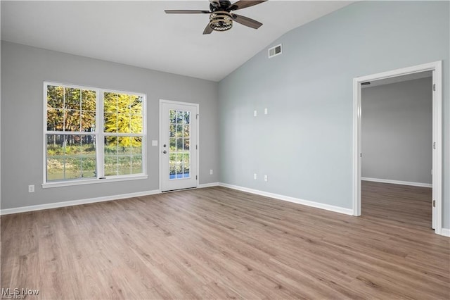 empty room with ceiling fan, visible vents, wood finished floors, baseboards, and lofted ceiling