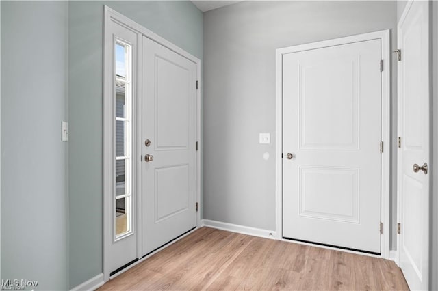 entryway featuring baseboards and light wood finished floors