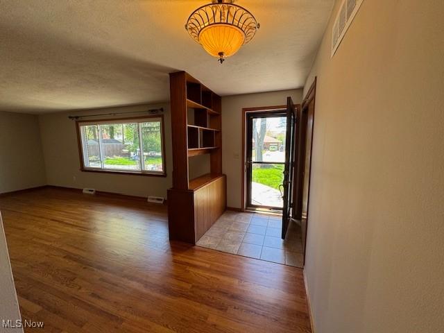 doorway to outside featuring a wealth of natural light, wood finished floors, and visible vents