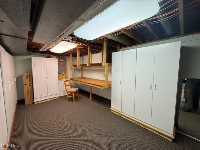 basement with carpet and electric panel