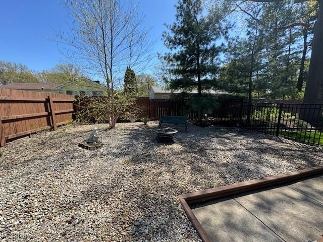 view of yard with a fenced backyard and a fire pit