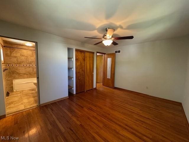 unfurnished bedroom with visible vents, a ceiling fan, baseboards, and wood finished floors