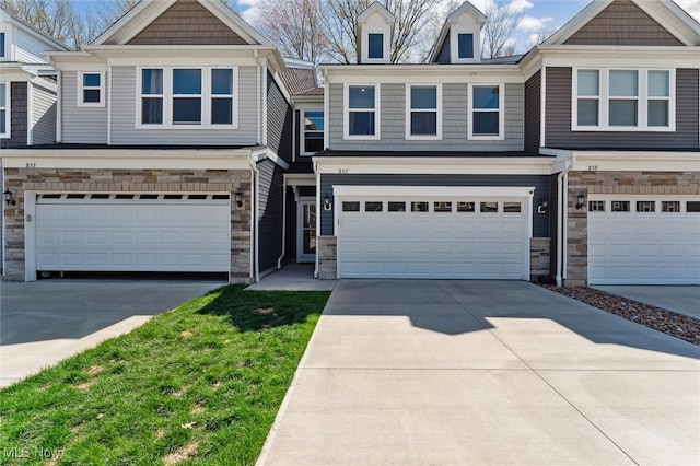 view of property featuring a garage, driveway, and stone siding