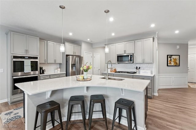 kitchen featuring a breakfast bar area, stainless steel appliances, a sink, and backsplash