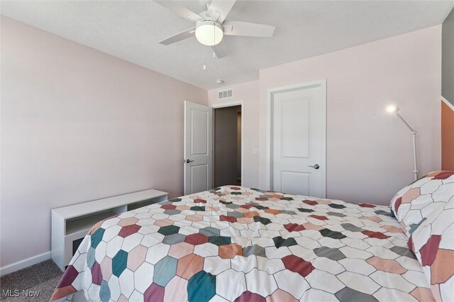 carpeted bedroom featuring visible vents and a ceiling fan