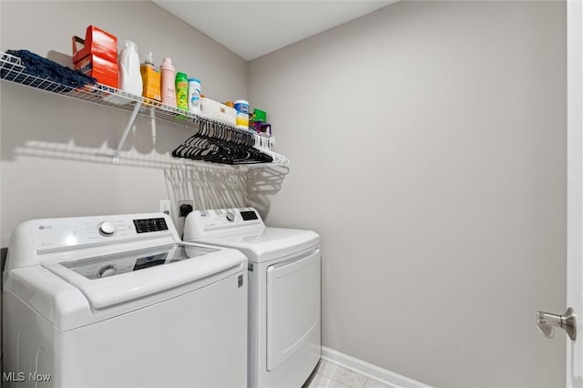 washroom featuring baseboards, laundry area, and washing machine and dryer