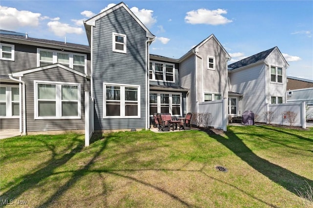 back of house with fence, a patio, and a yard