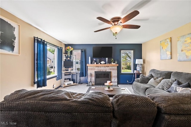 living room with a ceiling fan, plenty of natural light, and a fireplace
