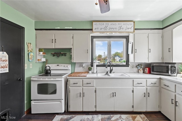 kitchen with a sink, white cabinets, stainless steel microwave, and electric range