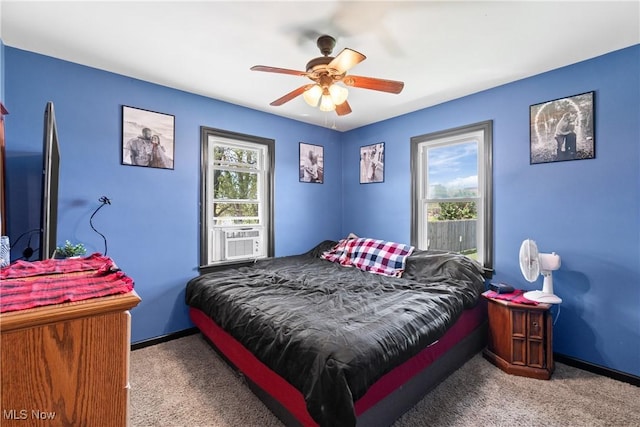 carpeted bedroom with a ceiling fan, baseboards, and cooling unit