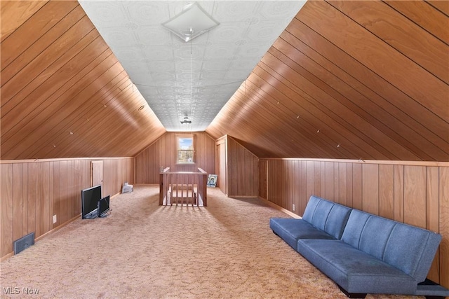 bonus room with carpet flooring, wood walls, and visible vents