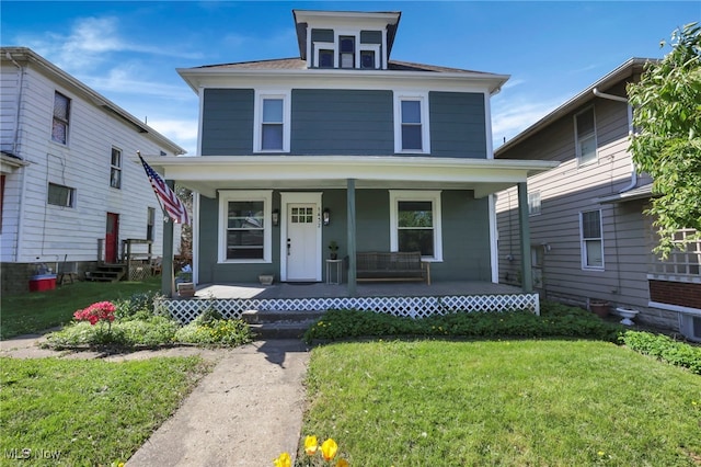 american foursquare style home with covered porch and a front lawn