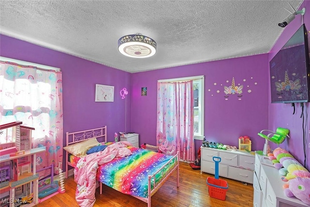 bedroom featuring a textured ceiling and hardwood / wood-style flooring
