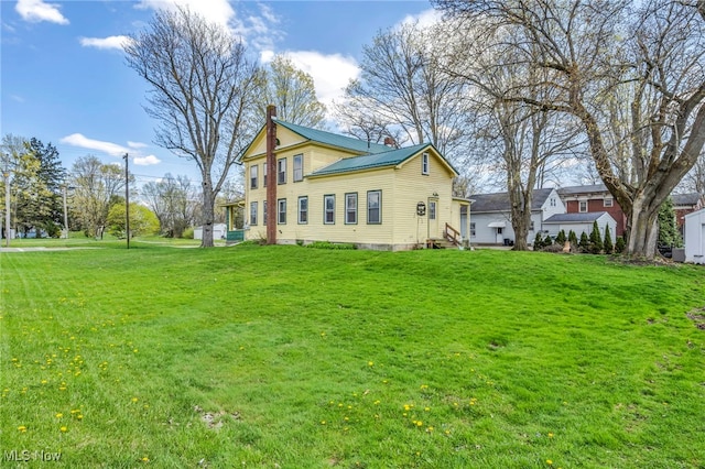 8935 S Main St, Windham, OH 44288 - back of house featuring a lawn, a chimney, and metal roof
