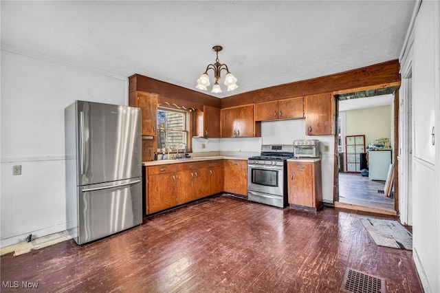 8935 S Main St, Windham, OH 44288 - kitchen featuring light countertops, an inviting chandelier, brown cabinetry, and stainless steel appliances