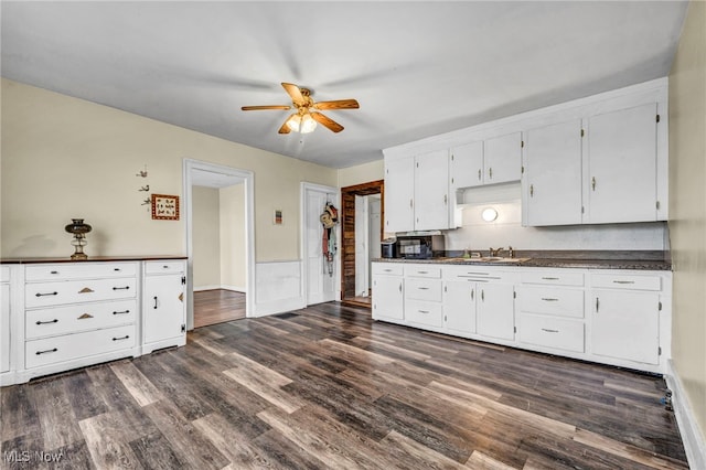 8935 S Main St, Windham, OH 44288 - kitchen with ceiling fan, dark countertops, dark wood finished floors, a sink, and white cabinetry