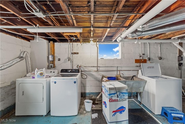 clothes washing area featuring separate washer and dryer and laundry area