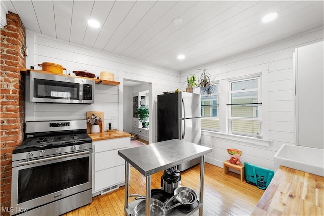 kitchen featuring light wood-type flooring, white cabinets, stainless steel appliances, recessed lighting, and butcher block countertops