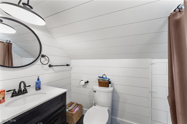 full bath with toilet, wood walls, lofted ceiling, and vanity