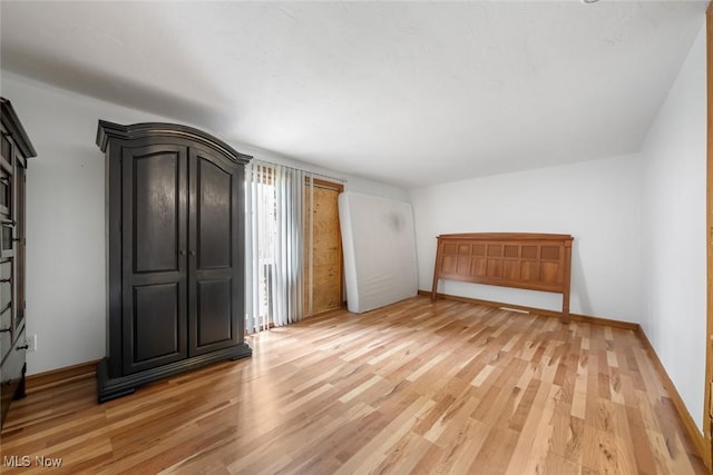 unfurnished bedroom featuring light wood-style floors and baseboards