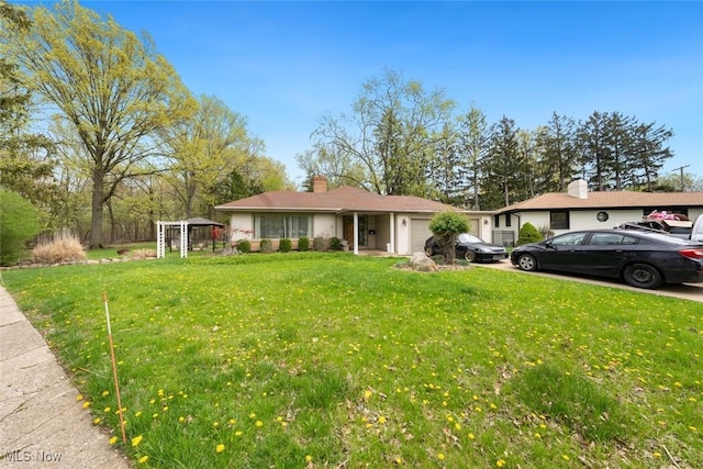 ranch-style home with an attached garage, a chimney, and a front lawn