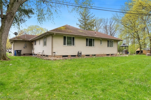 back of house featuring a lawn and a gazebo