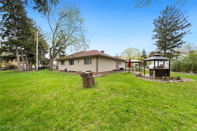 back of house with a gazebo and a lawn