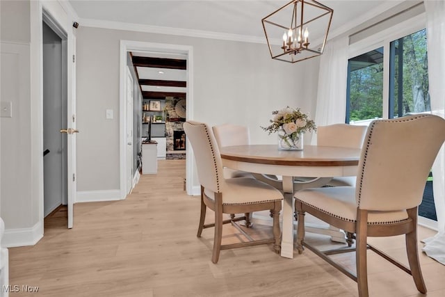 dining space featuring baseboards, a chandelier, ornamental molding, and light wood-style floors