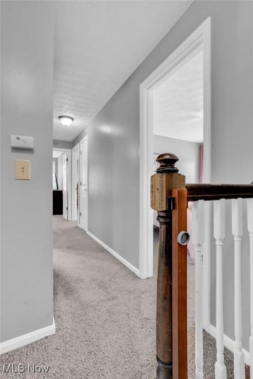 hall with carpet floors and baseboards