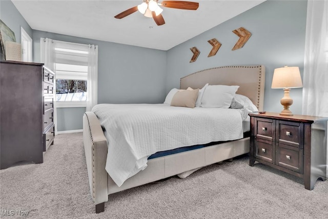 carpeted bedroom with a ceiling fan and baseboards