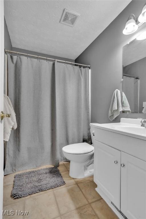 bathroom with toilet, visible vents, and vanity