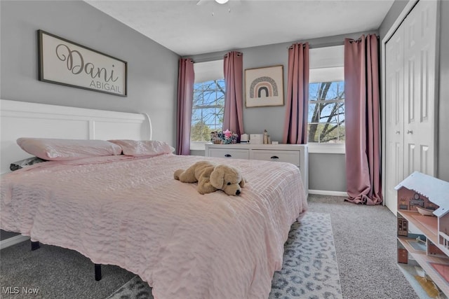 carpeted bedroom with a closet, a ceiling fan, and baseboards