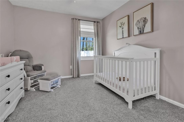 bedroom with carpet floors, baseboards, and a crib