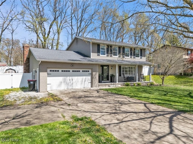 traditional home featuring a porch, driveway, brick siding, fence, and an attached garage