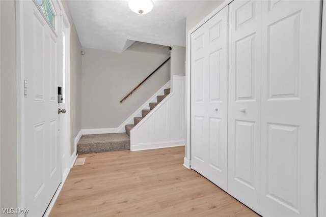 foyer entrance with stairway and light wood finished floors
