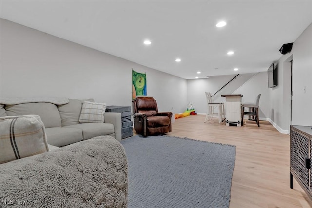 living area with baseboards, recessed lighting, and light wood finished floors