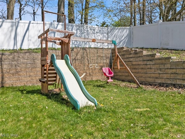 view of playground featuring a yard and fence