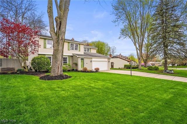 traditional-style house featuring concrete driveway, an attached garage, fence, and a front lawn
