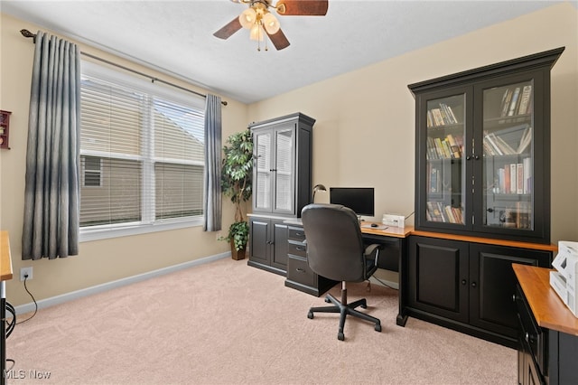 carpeted home office with baseboards and ceiling fan