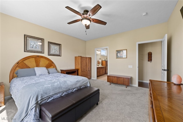 bedroom with connected bathroom, a ceiling fan, baseboards, and light colored carpet