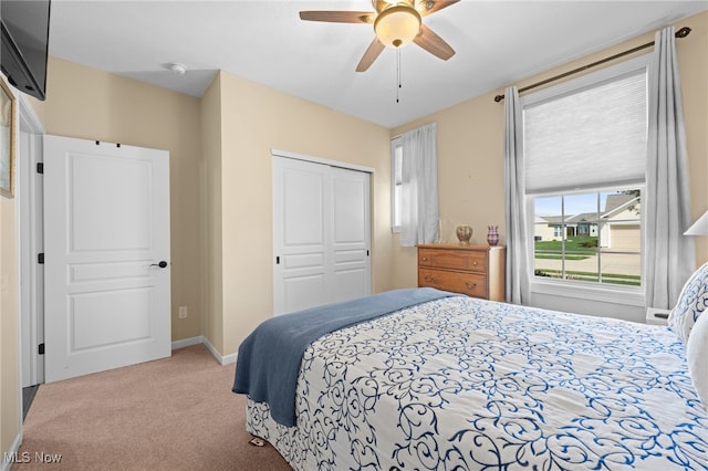 carpeted bedroom with a closet, a ceiling fan, and baseboards