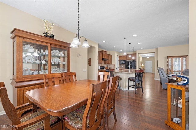 dining area featuring recessed lighting, dark wood finished floors, and a chandelier