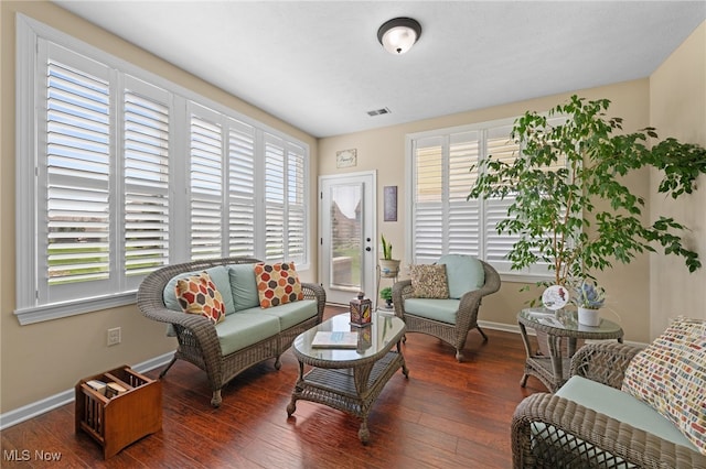 living area featuring baseboards, wood finished floors, and visible vents
