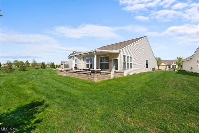 rear view of house with a lawn and central AC unit