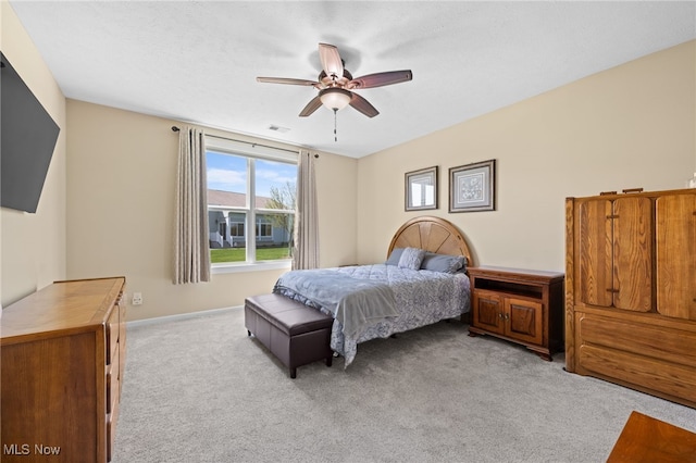 bedroom featuring light colored carpet, a ceiling fan, baseboards, and visible vents