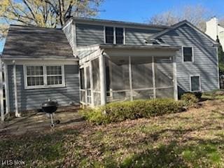 rear view of house with a chimney and a sunroom