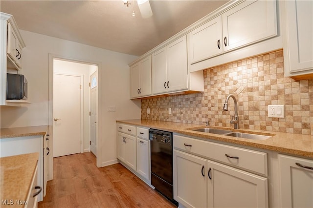 kitchen featuring a sink, black dishwasher, white cabinetry, decorative backsplash, and light wood-type flooring