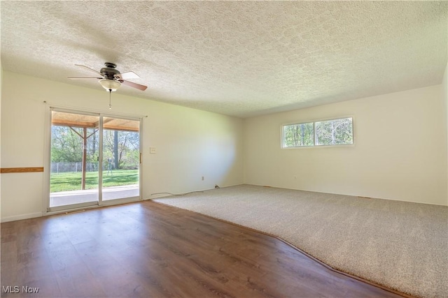 empty room featuring a textured ceiling, ceiling fan, and wood finished floors
