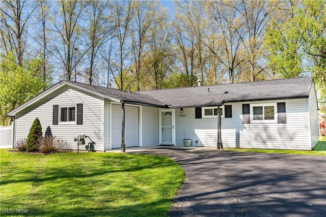 single story home featuring an attached garage, driveway, and a front yard